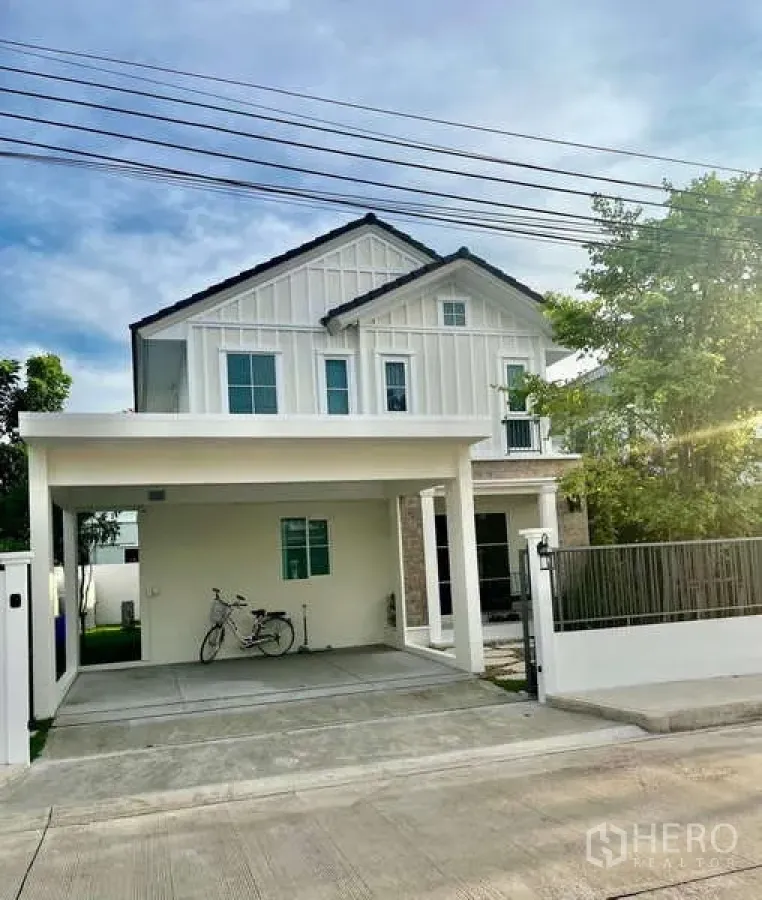 独立式住宅 出租在Bang Phli, Samut Prakan - 两层独栋别墅外观，带有车棚与前院大门。