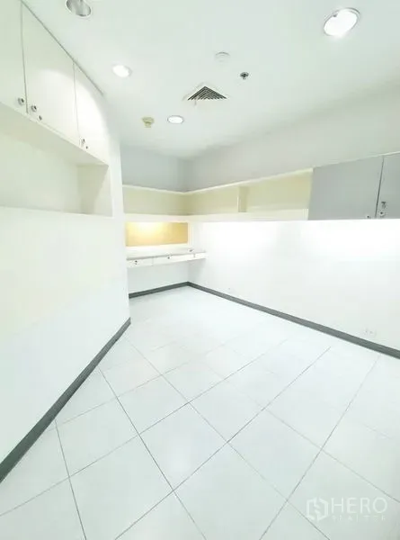 办公空间 出租在Bang Na, Bangkok - 紧凑工作间，内置柜体，白色瓷砖地面与嵌入式照明。