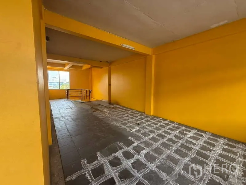 带办公室的家 出租在Khlong Toei, Bangkok - 楼层长廊区，一侧窗户与栏杆，黄色墙面与灰色地面。