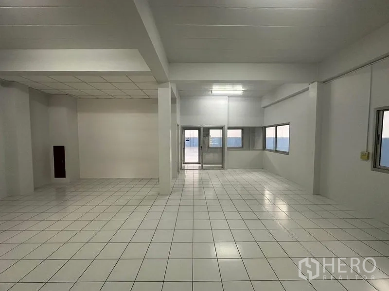 工厂 出租在Pathum Thani - 明亮的瓷砖地面生产/办公区，带窗户和双扇玻璃门。