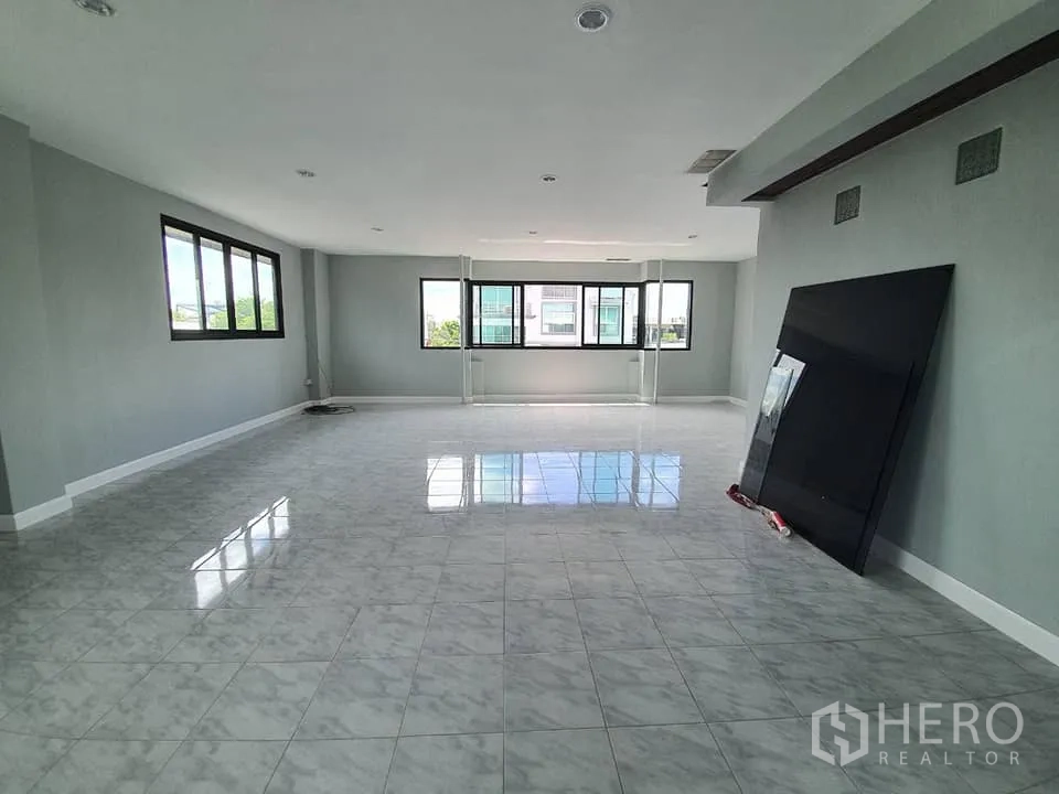 Home Office for rent in Wang Thonglang, Bangkok - Top‑floor open room with glossy tiles, multiple windows and abundant natural light.