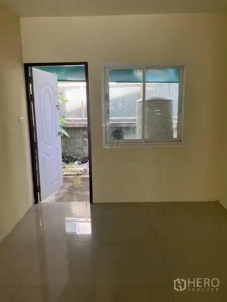Home Office for rent in Yan Nawa, Bangkok - Ground-floor room with a window and a door opening to a small rear service yard.