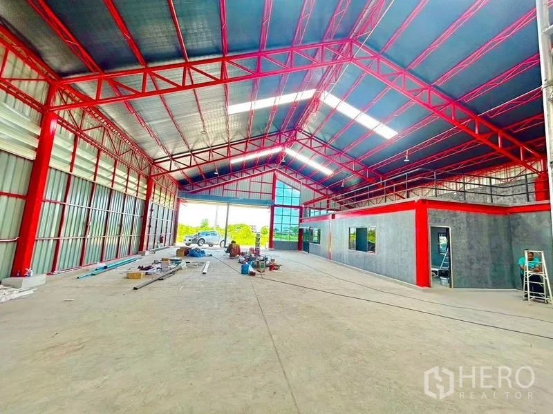 货栈 出租在Lam Luk Ka, Pathum Thani - 仓库内部空间高挑通透，红色钢桁架、混凝土地面与内部办公室。