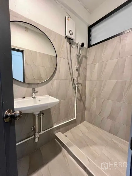 Home Office for rent in Khlong Toei, Bangkok - Tiled bathroom with step-in shower, round mirror and water heater.