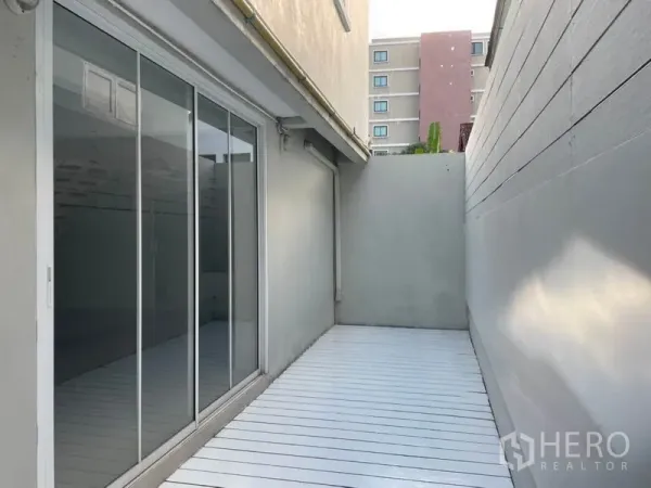 Detached House for rent in Huai Khwang, Bangkok - Private side deck with high privacy wall and full-height sliding glass doors.