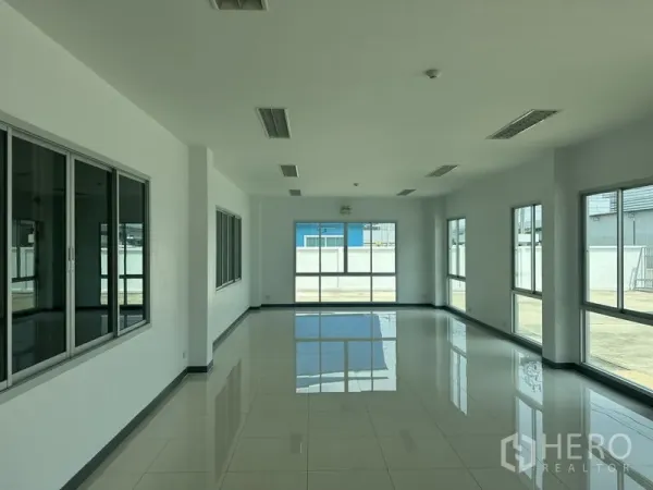 工厂 出租在Bang Sao Thong, Samut Prakan - 采光充足的玻璃围合办公室，亮面地砖，窗户面向院区。