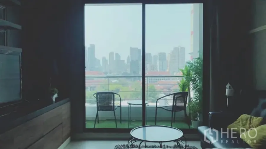 公寓 出租在Watthana, Bangkok - 客厅通向阳台，摆两把椅子，可眺望曼谷城市天际线。