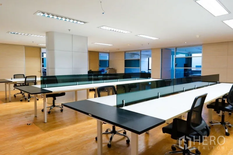 Office Space for rent - Bright open-plan office with long bench desks, task chairs and wood flooring.