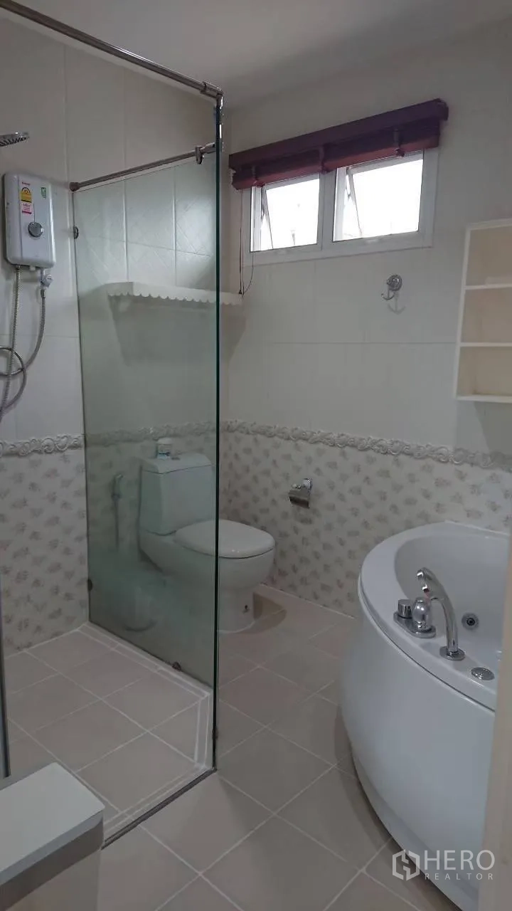 Detached House for rent in Mueang Samut Prakan, Samut Prakan - Ensuite bathroom featuring a glass shower, patterned tiles and a round Jacuzzi tub.