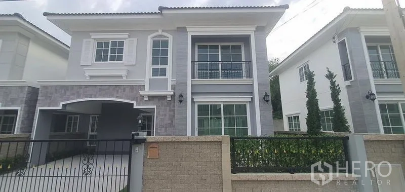 Detached House for rent in Nonthaburi - Gated modern two-storey house with balcony and driveway in a Pak Kret, Nonthaburi community.