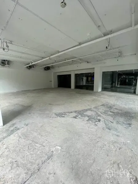 Retail Space for rent in Watthana, Bangkok - Spacious white-box interior with exposed ceiling services, concrete floor and corner glazing.