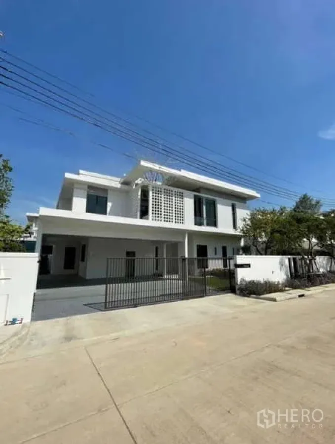 Detached House for rent in Samut Prakan - Front facade of modern detached house with gated driveway.