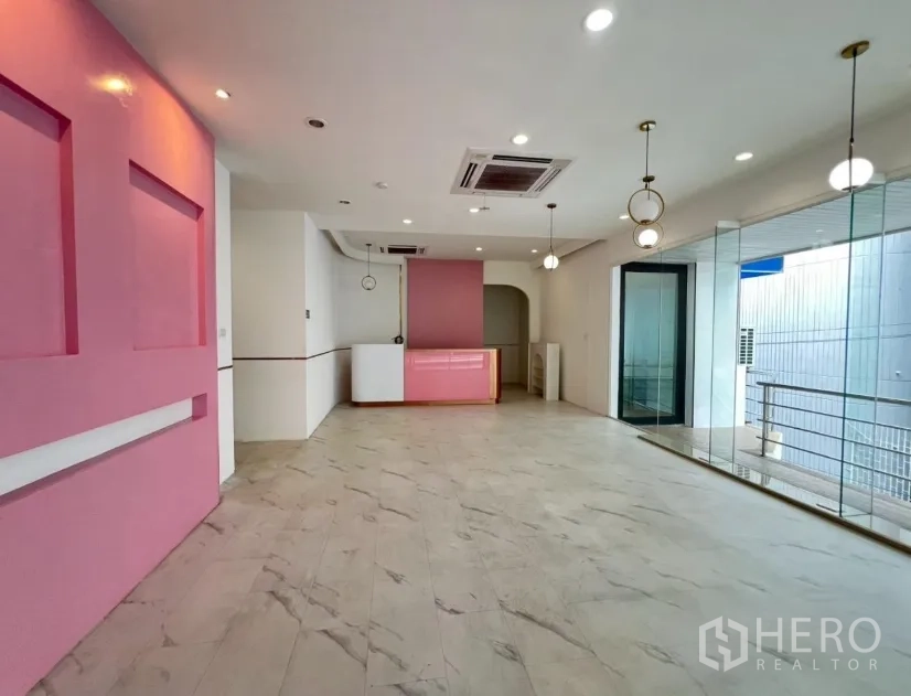 Retail Space for rent in Watthana, Bangkok - Bright retail space with marble-look floors, pink feature wall, glass frontage and pendant lighting.