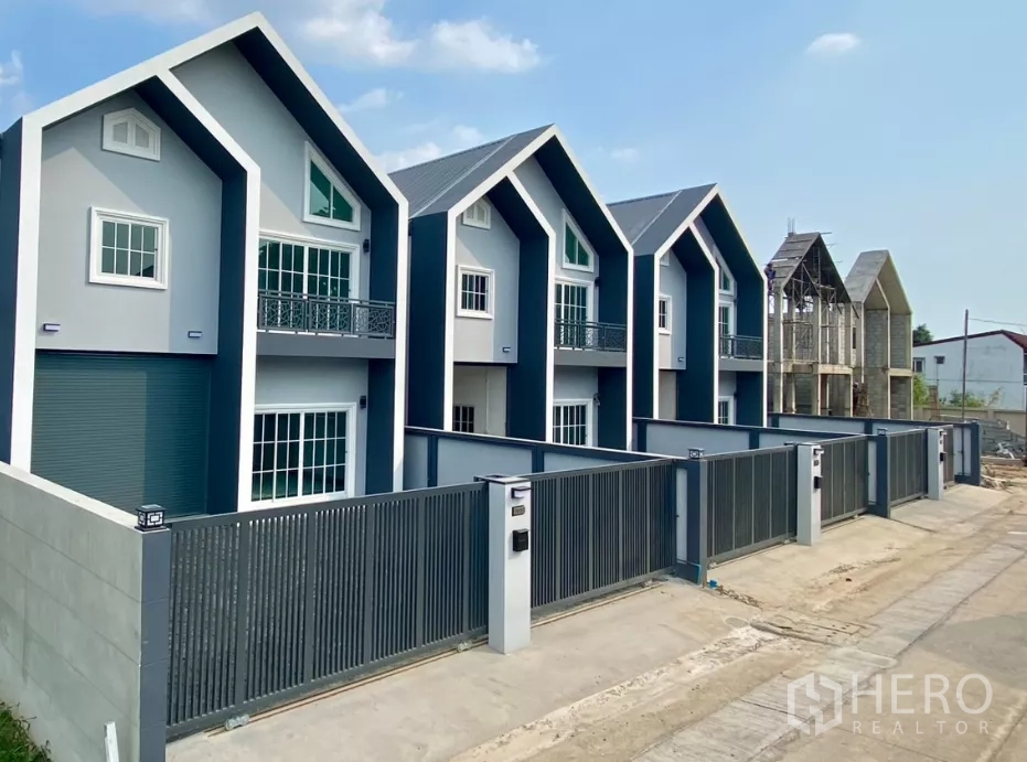 Factory for rent or sale in Bang Bua Thong, Nonthaburi - Row of modern factory units with steep gable roofs and secure front fences.