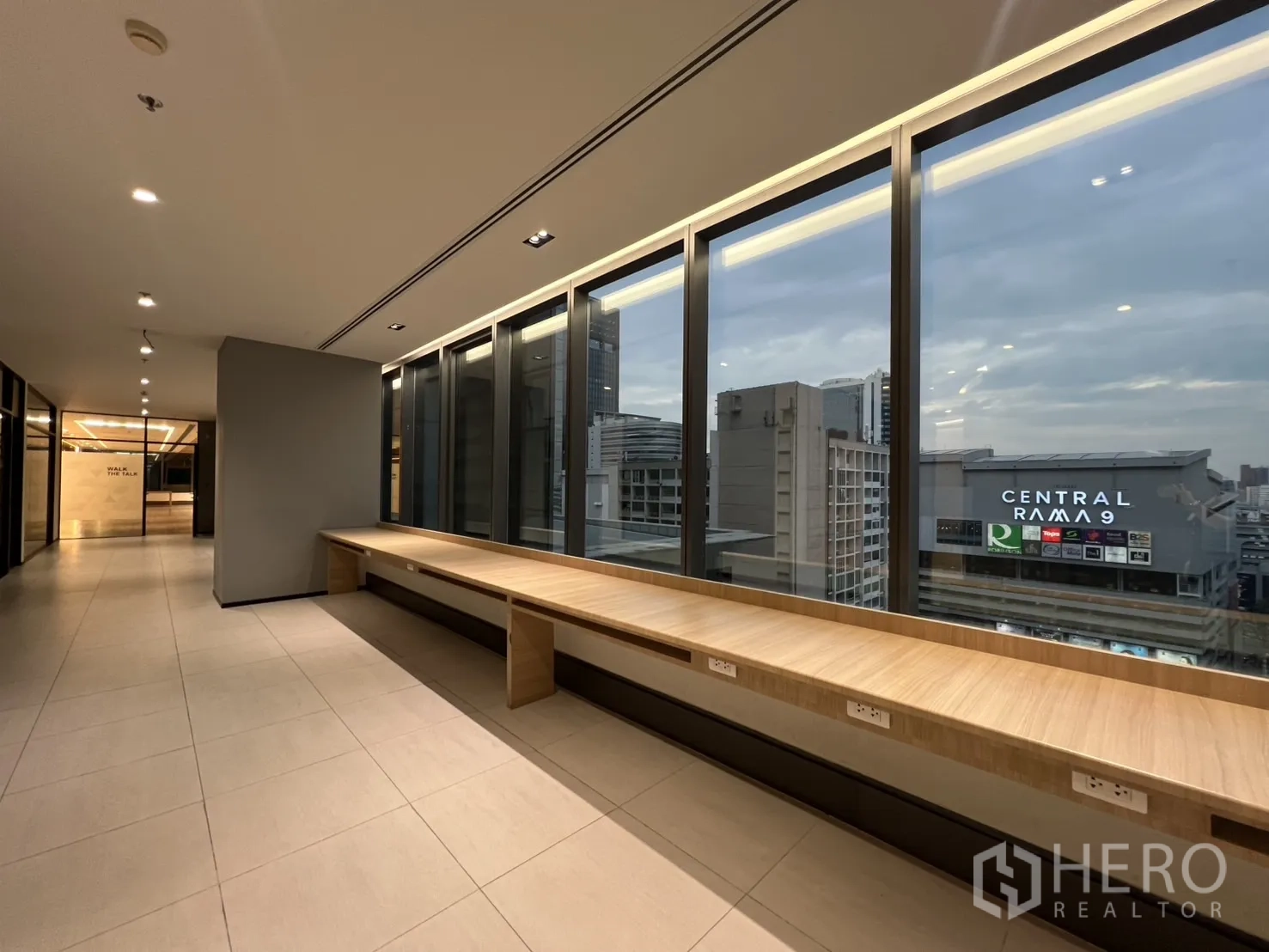 办公空间 出租在Huai Khwang, Bangkok - 临窗走道配长座台与插座，可眺望Central Plaza Grand Rama 9。