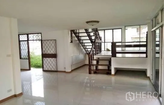 Office Space for rent in Chatuchak, Bangkok - Spacious open office with staircase, glass partitions and security grilles facing the garden.