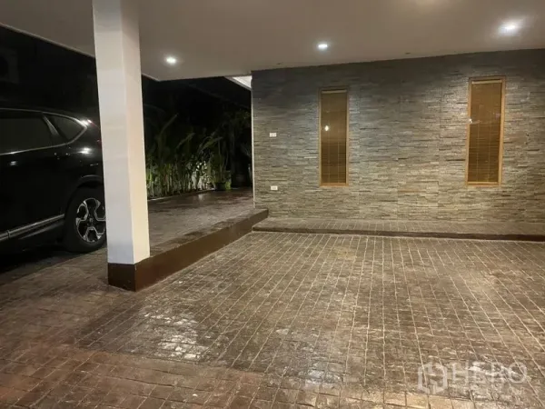 联排别墅 出租在Suan Luang, Bangkok - 带顶车库与石材墙面，砖纹车道和嵌入式照明，旁有绿植