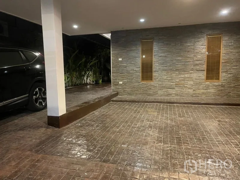 联排别墅 出租在Suan Luang, Bangkok - 带顶车库与石材墙面，砖纹车道和嵌入式照明，旁有绿植
