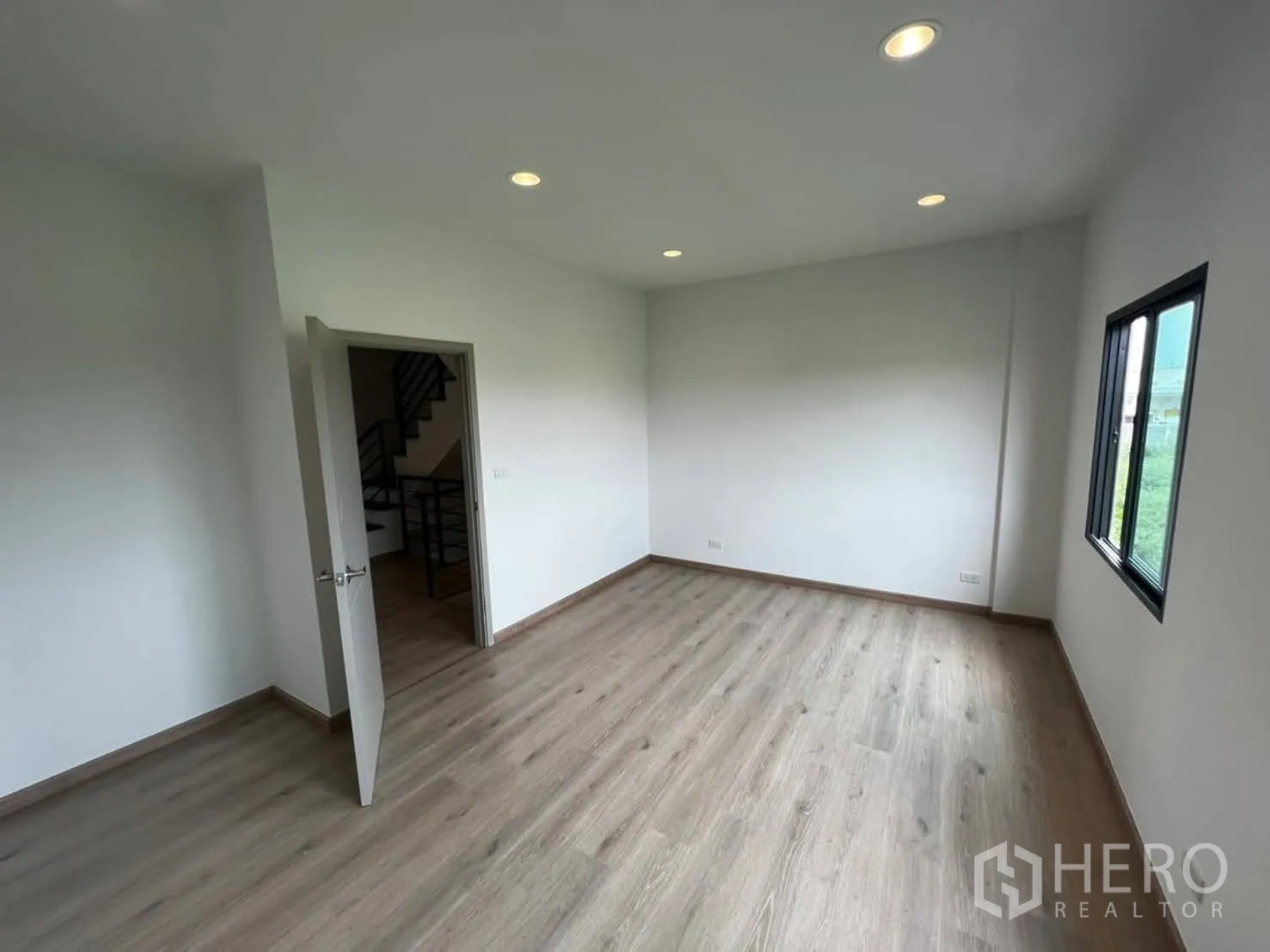 Townhouse for rent in Bang Khen, Bangkok - Upper-floor bedroom with twin windows providing natural light and views.