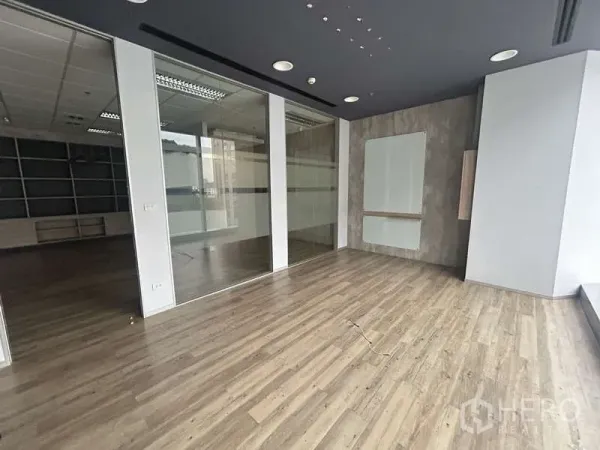 Office Space for rent - Open workspace with glass-partitioned rooms and modern ceiling lighting