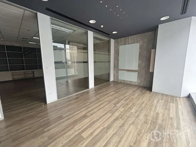 Office Space for rent - Open workspace with glass-partitioned rooms and modern ceiling lighting