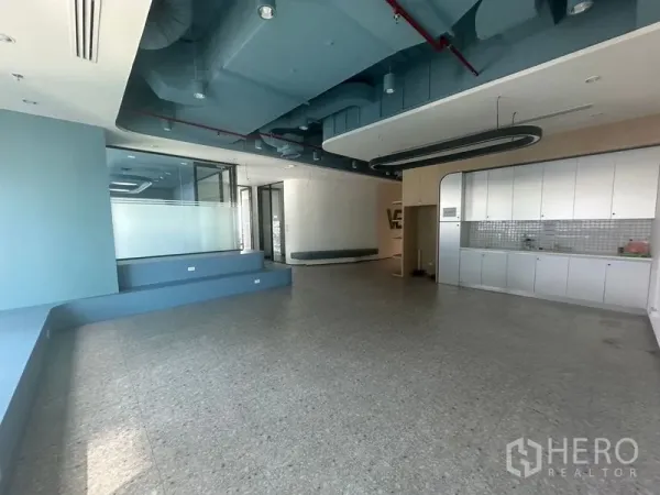 Office Space for rent in Ratchathewi, Bangkok - Reception lounge with pantry cabinets and exposed ceiling ducts.