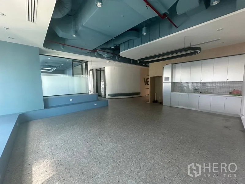 Office Space for rent in Ratchathewi, Bangkok - Reception lounge with pantry cabinets and exposed ceiling ducts.