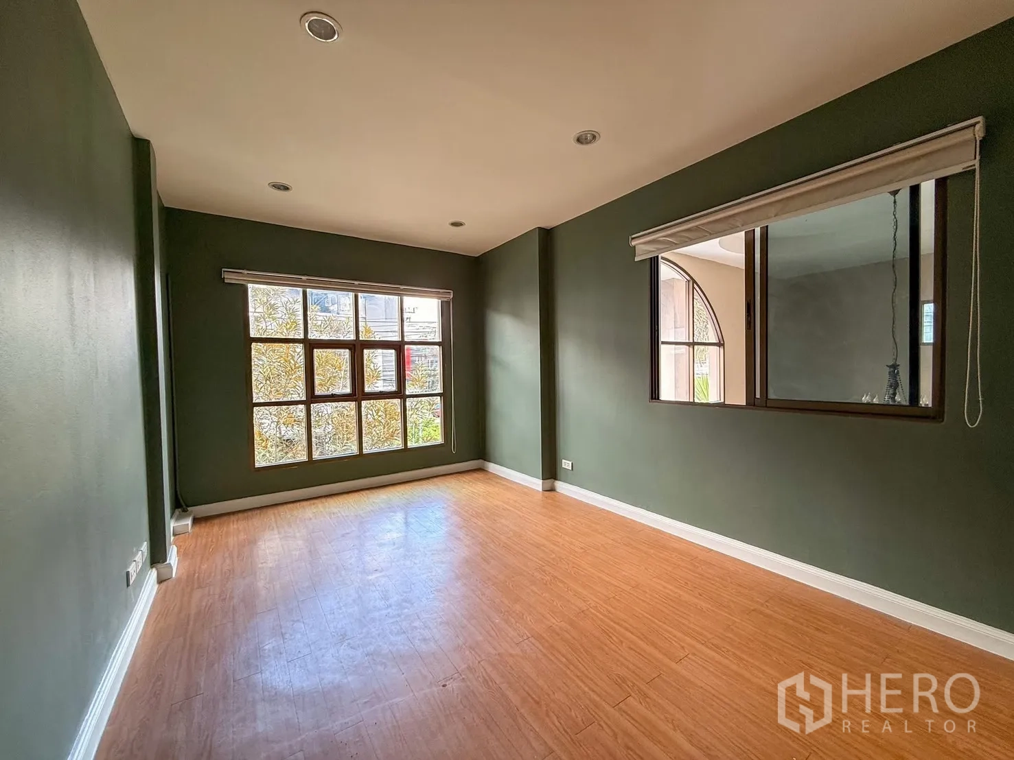 Home Office for rent in Wang Thonglang, Bangkok - Office room with green accent walls, a large grid window and interior window.