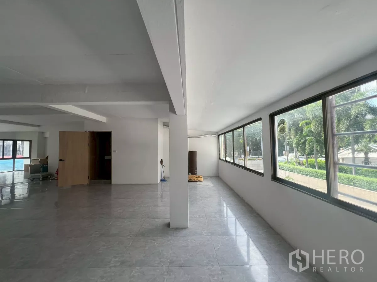 Retail Space for rent in Pathum Wan, Bangkok - Bright corridor lined with long windows overlooking palm trees and greenery.