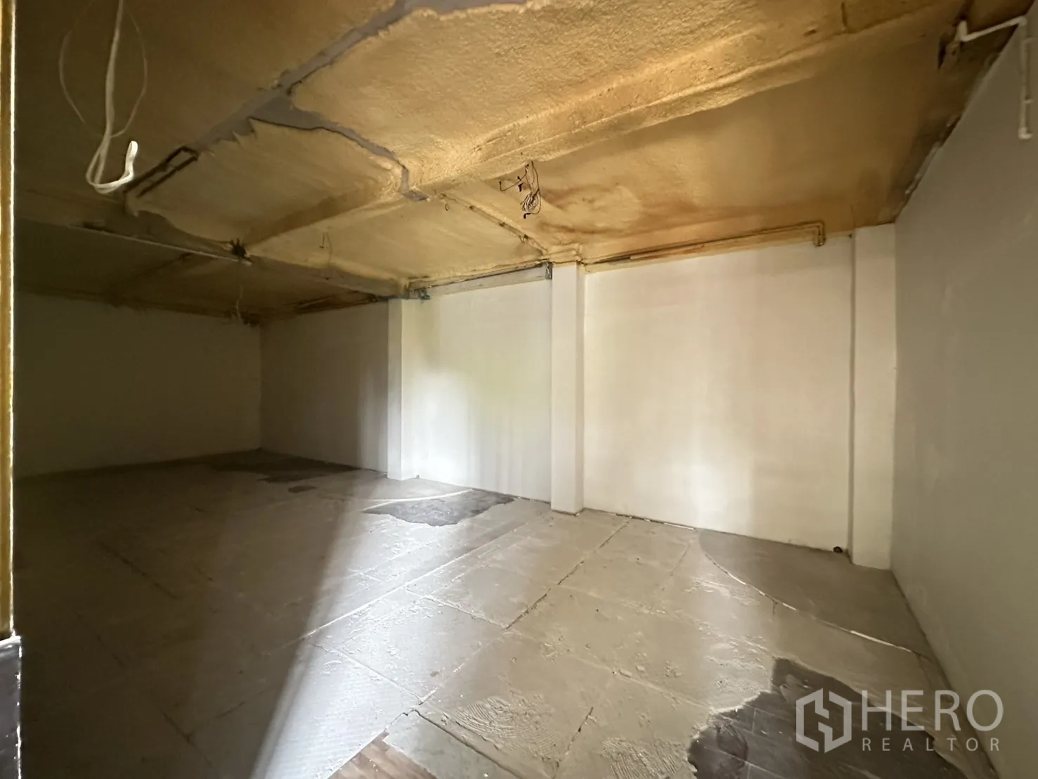 Retail Space for rent in Bang Rak, Bangkok - Empty white‑walled room with low ceiling, ideal for storage or private area.