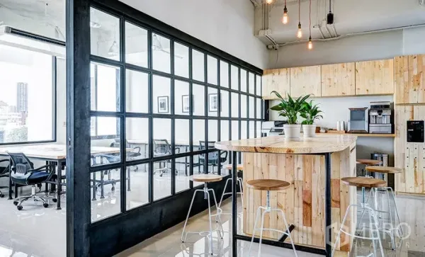 Office Space for rent in Khlong Toei, Bangkok - Pantry and breakout area with wooden island bar, high stools, coffee machines and a glass partition.