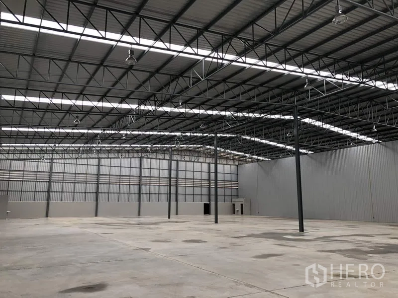 Warehouse for rent in Lat Krabang, Bangkok - Spacious warehouse interior with high steel truss roof, skylight strips, and polished concrete floor.