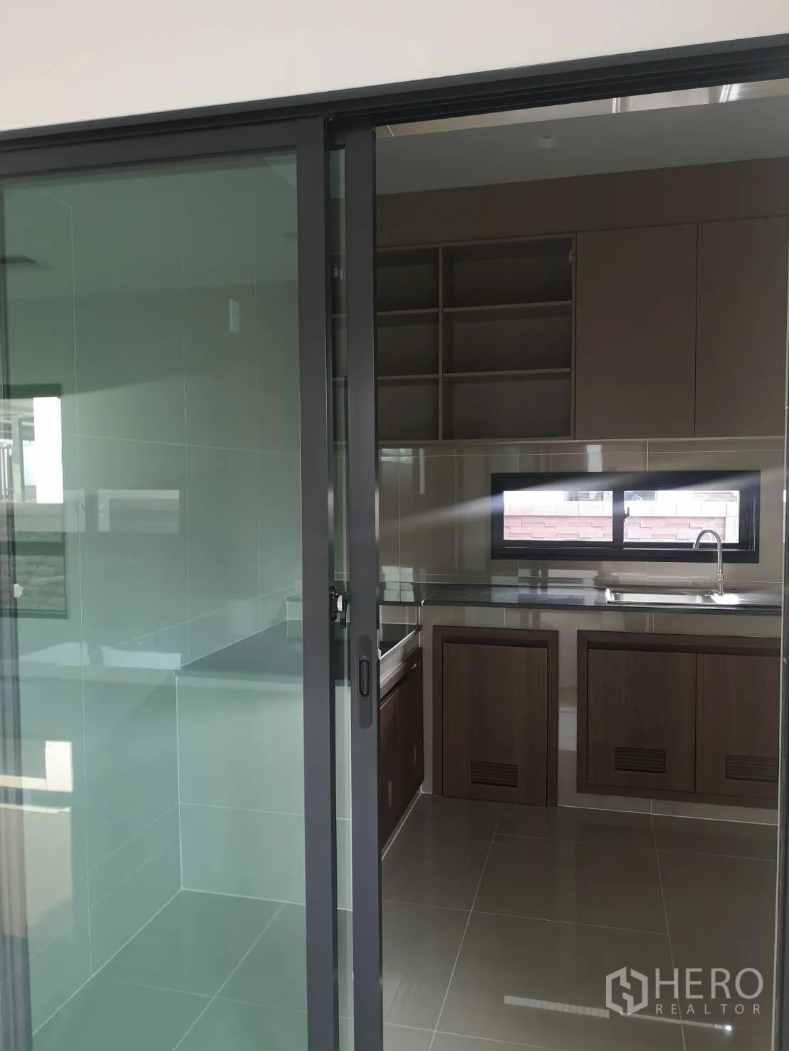 Detached House for sale in Lam Luk Ka, Pathum Thani - Built-in Thai kitchen with cabinets, countertop and sink beneath a window.