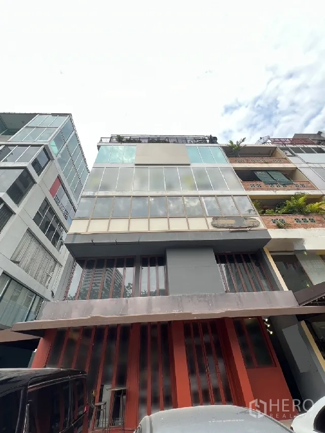 Retail Space for rent - Multi-storey commercial building with glass facade and red storefront in Watthana, Bangkok.