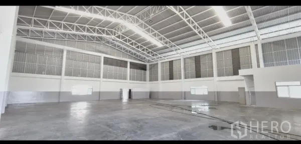 Factory for rent in Mueang Samut Prakan, Samut Prakan - Open production floor with polished concrete, tall walls and ventilation panels around the perimeter.