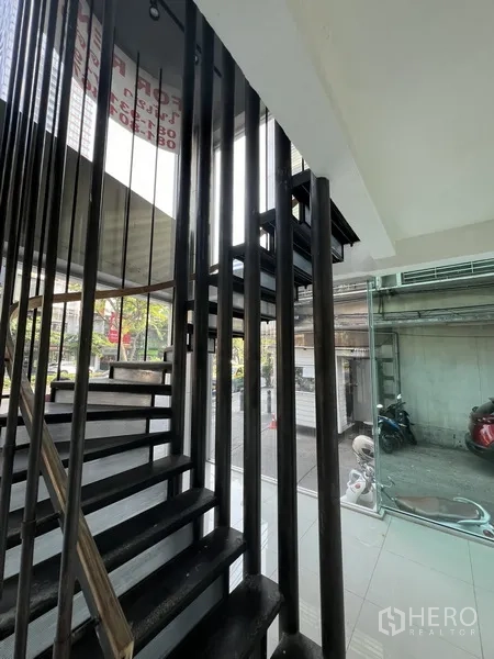 Retail Space for rent in Bang Rak, Bangkok - Metal staircase with vertical black rails beside a full-height glass wall.