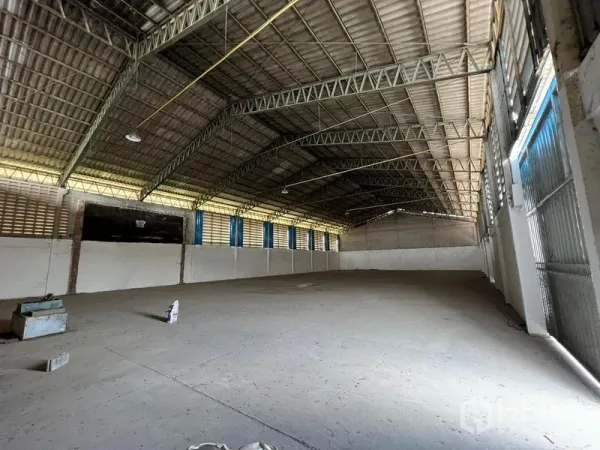 Warehouse for rent in Bang Pa-in, Phra Nakhon Si Ayutthaya - Warehouse bay with arched truss roof, louvered side windows and large sliding metal door.