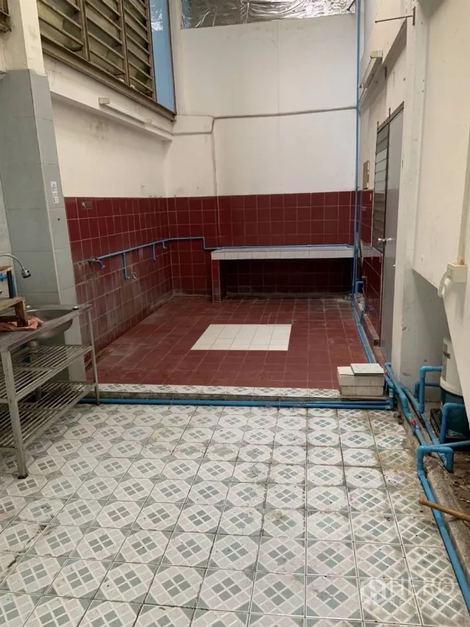 Shophouse for rent in Suan Luang, Bangkok - Rear utility or wet area with red wall tiles, sink and exposed blue plumbing.