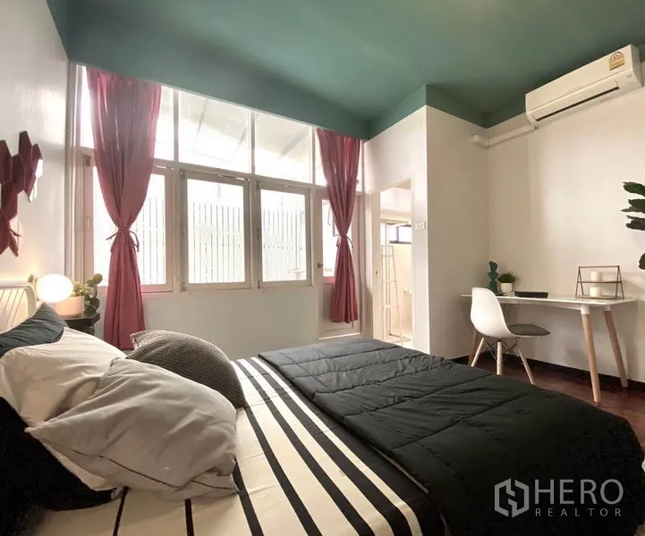 Townhouse for rent in Khlong Toei, Bangkok - Bedroom view to study desk, air-conditioning and en-suite entry with natural light.