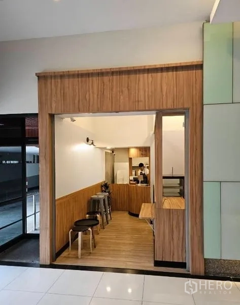 Retail Space for rent in Watthana, Bangkok - Open storefront framed in wood showing seating and a small back-of-house area.