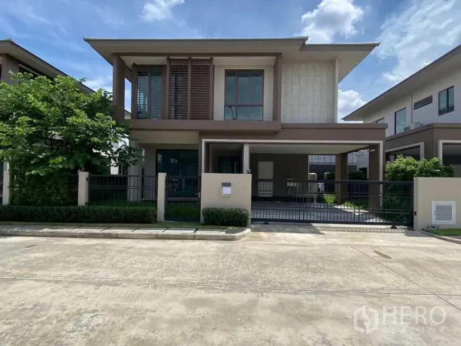 Detached House for rent in Bang Kapi, Bangkok - Modern two-storey detached house with gated carport in Hua Mak, Bang Kapi under a blue sky.