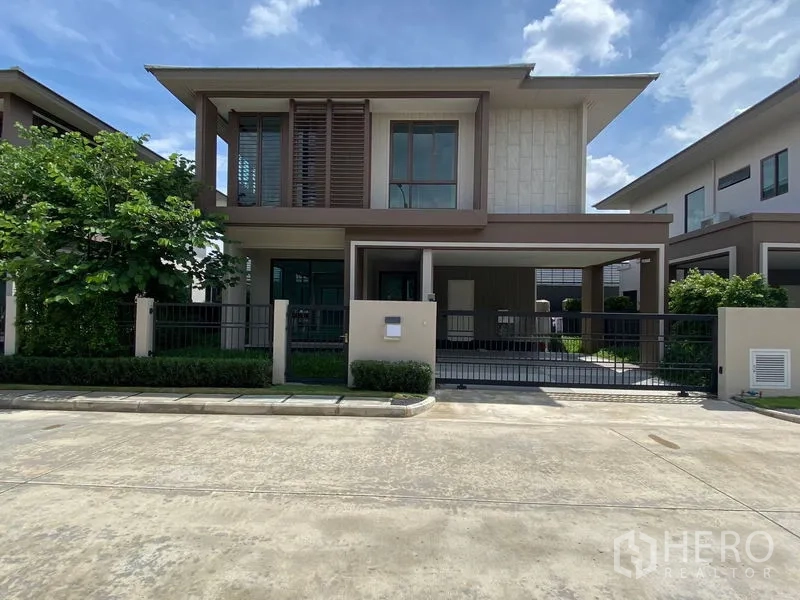 Detached House for rent in Bang Kapi, Bangkok - Modern two-storey detached house with gated carport in Hua Mak, Bang Kapi under a blue sky.