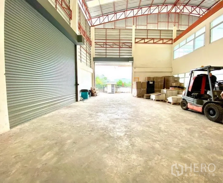 Warehouse for rent in Lam Luk Ka, Pathum Thani - Large roller shutter loading door with forklift area inside the warehouse.