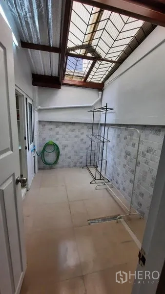 联排别墅 出租或出售在Suan Luang, Bangkok - 半室外家务区，采光顶、瓷砖墙面与地漏。