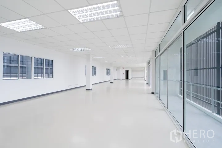 Factory for rent in Khlong Luang, Pathum Thani - Bright office floor with grid ceiling, fluorescent lighting, windows, and glass partitions.