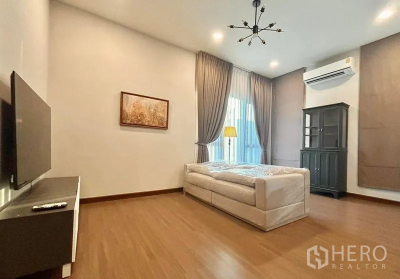 Detached House for rent - Primary suite with sitting area, TV and warm wood-look flooring.