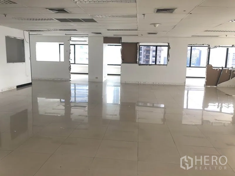 Office Space for rent in Watthana, Bangkok - Large empty office floor with drop ceiling and wraparound windows.