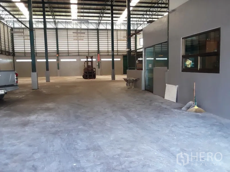 Factory for rent in Saphan Sung, Bangkok - Wide warehouse aisle with internal office glazing, pickup truck and open floor space.