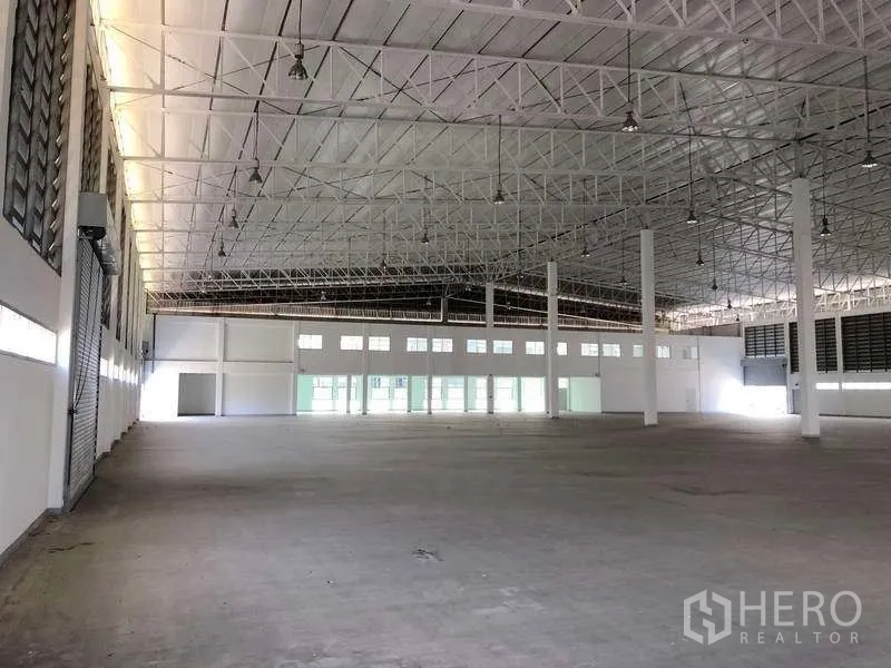 Factory for rent or sale in Phra Nakhon Si Ayutthaya - Expansive manufacturing area facing the office frontage with rows of windows.