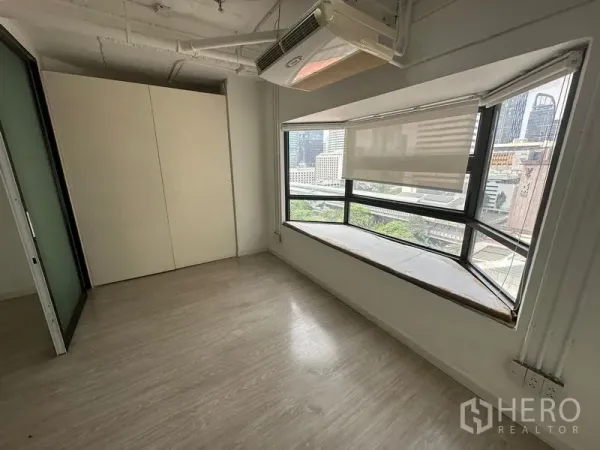 Office Space for rent in Pathum Wan, Bangkok - Compact office room with bay window, roller shades, wood flooring and Bangkok city view.